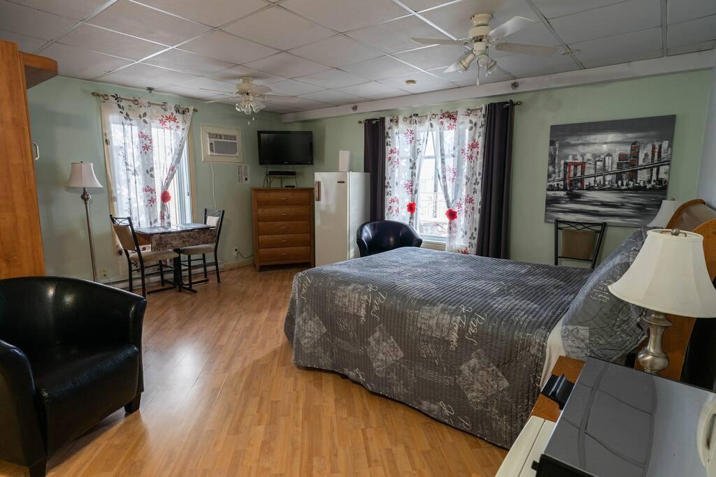 Sage-green room with a refrigerator, a TV on a dresser and a black-and-white city skyline canvas print
